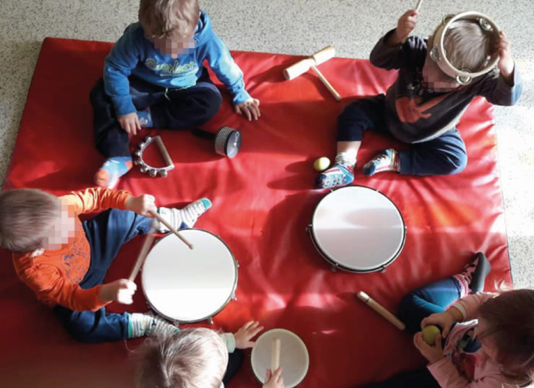 Bambini dell'Asilo Valli suonano tamburelli e altri strumenti.